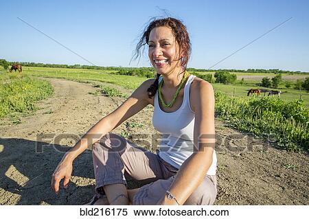 Hispanic woman sitting on dirt path in rural field View Large Photo Image Stock Photography - Hispanic woman sitting on dirt path in rural field. Fotosearch