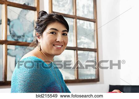 Stock Photo - Hispanic woman smiling in cafe. Fotosearch