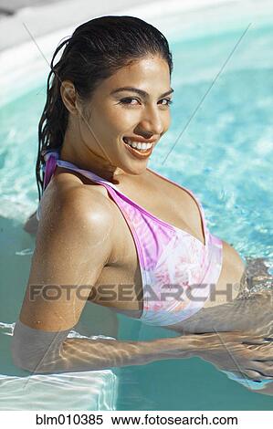 Stock Photography - Hispanic woman swimming in swimming pool. Fotosearch