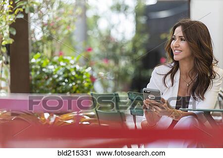 Hispanic woman using cell phone outdoors View Large Photo Image Stock Image - Hispanic woman using cell phone outdoors. Fotosearch