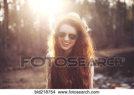 Picture - Hispanic woman walking by pond in park. Fotosearch