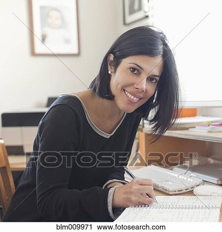 Hispanic woman working in home office View Large Photo Image Stock Image - Hispanic woman working in home office. Fotosearch