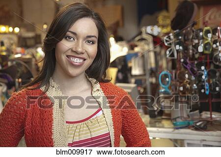 Stock Photo - Hispanic woman working in vintage store. Fotosearch