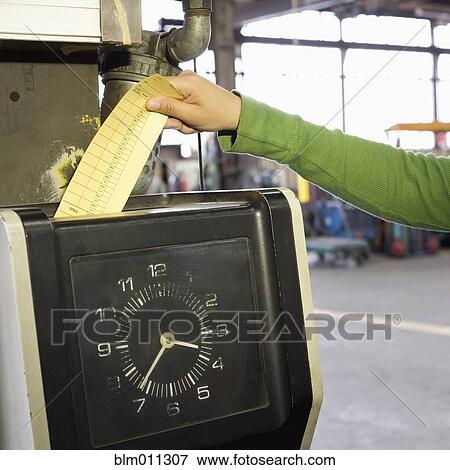 Stock Photo - Hispanic worker clocking in in factory. Fotosearch