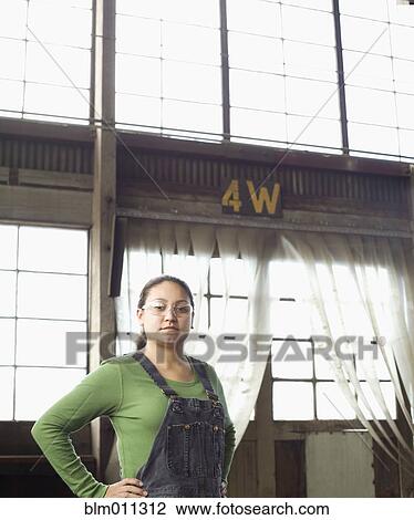 Stock Image - Hispanic worker standing in warehouse. Fotosearch