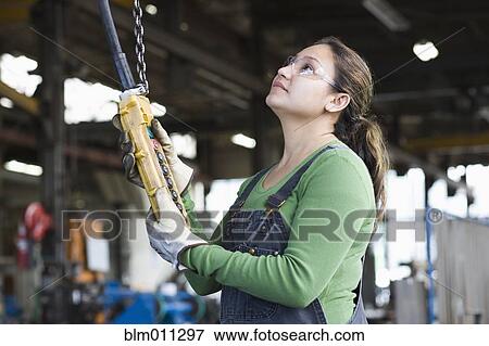 Stock Photo - Hispanic worker using control panel in warehouse. Fotosearch