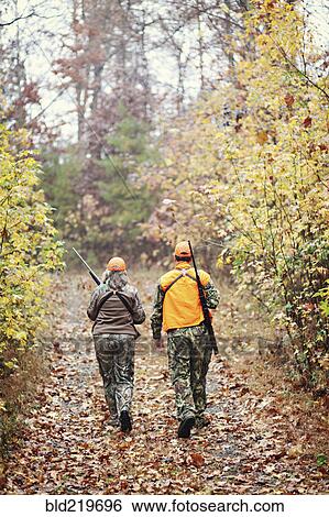 Hunters in camouflage carrying rifles in forest View Large Photo Image Stock Photograph - Hunters in camouflage carrying rifles in forest. Fotosearch