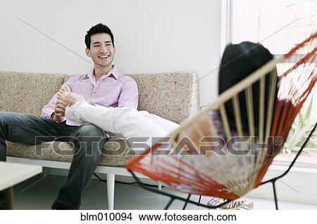 Husband rubbing wife's feet in living room View Large Photo Image Picture - Husband rubbing wife's feet in living room. Fotosearch
