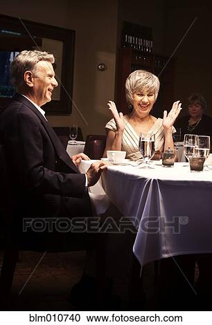 Husband surprising wife with gift in restaurant View Large Photo Image Stock Image - Husband surprising wife with gift in restaurant. Fotosearch