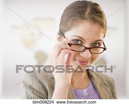 Indian businesswoman adjusting eyeglasses View Large Photo Image Picture - Indian businesswoman adjusting eyeglasses. Fotosearch