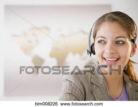 Indian businesswoman talking on headset in office View Large Photo Image Stock Photograph - Indian businesswoman talking on headset in office. Fotosearch