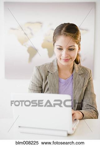 Indian businesswoman using laptop in office View Large Photo Image Stock Photography - Indian businesswoman using laptop in office. Fotosearch