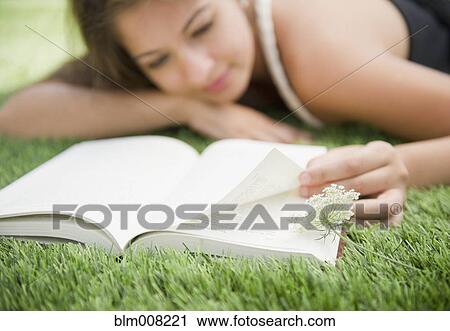 Indian woman laying in grass reading book View Large Photo Image Stock Image - Indian woman laying in grass reading book. Fotosearch