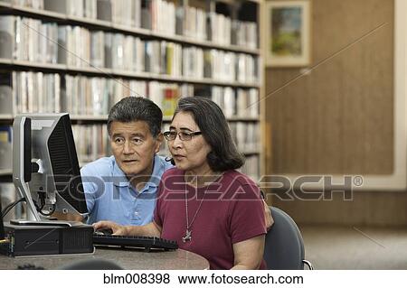 Japanese couple using computer in library View Large Photo Image Stock Photo - Japanese couple using computer in library. Fotosearch
