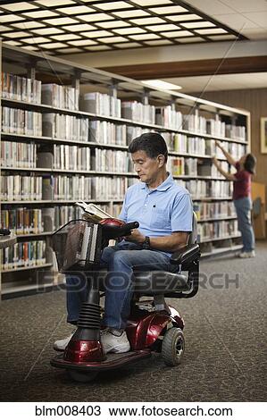 Japanese man in motorized scooter reading book in library View Large Photo Image Stock Image - Japanese man in motorized scooter reading book in library. Fotosearch