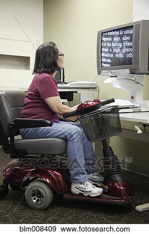 Japanese woman in motorized scooter using computer in library View Large Photo Image Stock Photo - Japanese woman in motorized scooter using computer in library. Fotosearch