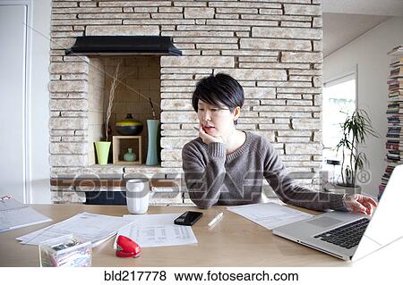 Japanese woman paying bills on laptop View Large Photo Image Stock Photo - Japanese woman paying bills on laptop. Fotosearch