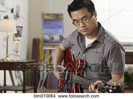 Korean man playing electric guitar View Large Photo Image Picture - Korean man playing electric guitar. Fotosearch