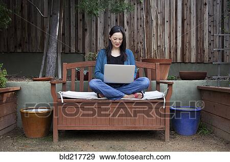 Korean woman using laptop in backyard View Large Photo Image Stock Photo - Korean woman using laptop in backyard. Fotosearch
