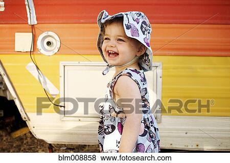 Stock Photo - Laughing Caucasian girl near camper. Fotosearch