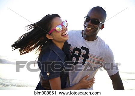 Laughing couple enjoying beach View Large Photo Image Stock Image - Laughing couple enjoying beach. Fotosearch