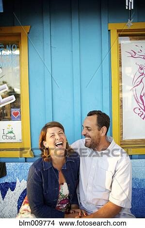 Laughing couple sitting together View Large Photo Image Picture - Laughing couple sitting together. Fotosearch