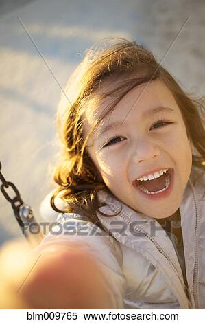 Laughing mixed race girl swinging View Large Photo Image Stock Photography - Laughing mixed race girl swinging. Fotosearch