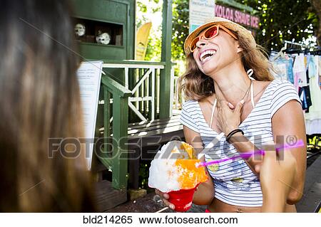 Stock Photography - Laughing woman eating shaved ice. Fotosearch