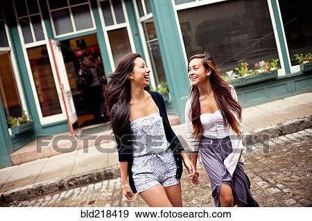 Laughing women crossing cobblestone street View Large Photo Image Stock Photo - Laughing women crossing cobblestone street. Fotosearch