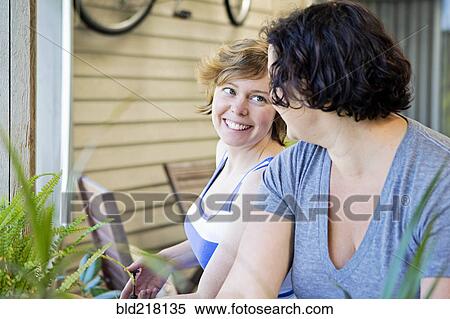 Lesbian couple relaxing in backyard View Large Photo Image Stock Photography - Lesbian couple relaxing in backyard. Fotosearch