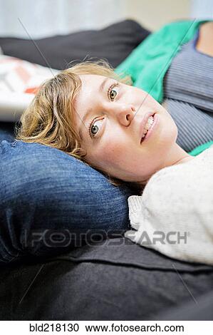 Lesbian couple relaxing on sofa in living room View Large Photo Image Stock Image - Lesbian couple relaxing on sofa in living room. Fotosearch