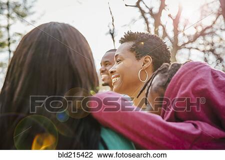 Stock Image - Low angle view of Black family smiling outdoors. Fotosearch