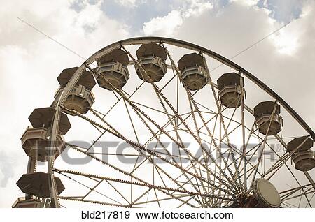 Stock Photo - Low angle view of ferris wheel at amusement park. Fotosearch