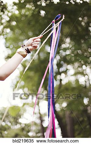 Stock Photography - Low angle view of girl playing with ribbons outdoors. Fotosearch