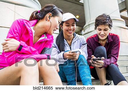 Low angle view of runners using cell phones on staircase View Large Photo Image Stock Photography - Low angle view of runners using cell phones on staircase. Fotosearch