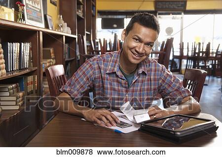 Malaysian business owner working in cafe View Large Photo Image Stock Photo - Malaysian business owner working in cafe. Fotosearch