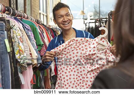 Stock Image - Malaysian man shopping in vintage store. Fotosearch