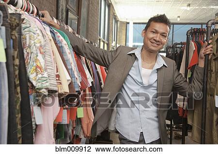 Stock Image - Malaysian man shopping in vintage store. Fotosearch