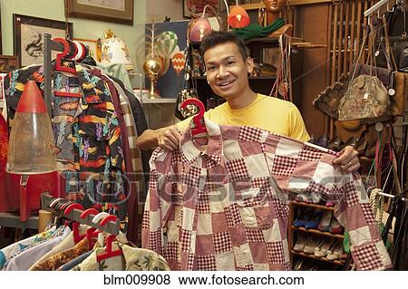 Malaysian man shopping in vintage store View Large Photo Image Stock Photo - Malaysian man shopping in vintage store. Fotosearch