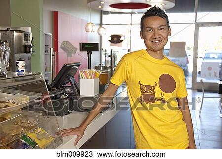 Stock Image - Malaysian man working in cafe. Fotosearch
