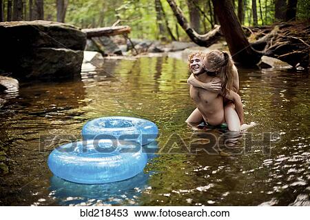 Man carrying girlfriend piggyback in forest river View Large Photo Image Stock Image - Man carrying girlfriend piggyback in forest river. Fotosearch