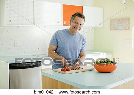 Man cutting vegetables in kitchen View Large Photo Image Stock Image - Man cutting vegetables in kitchen. Fotosearch