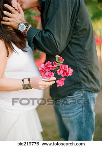 Man kissing pregnant wife outdoors View Large Photo Image Stock Photograph - Man kissing pregnant wife outdoors. Fotosearch