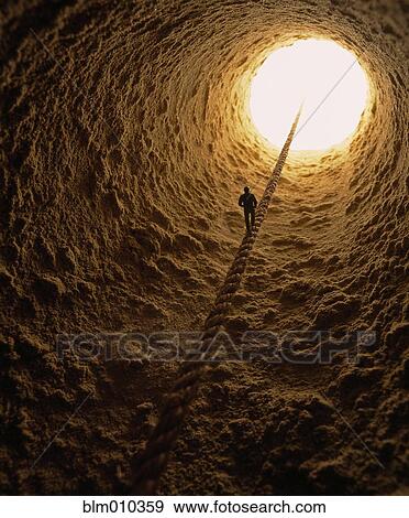 Man walking down rope into hole View Large Photo Image Stock Photo - Man walking down rope into hole. Fotosearch