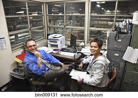 Manager and worker sitting in factory office View Large Photo Image Stock Image - Manager and worker sitting in factory office. Fotosearch
