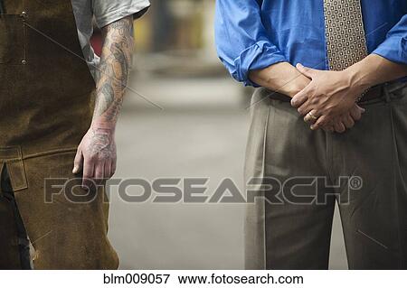 Manager and worker standing in factory View Large Photo Image Stock Photo - Manager and worker standing in factory. Fotosearch