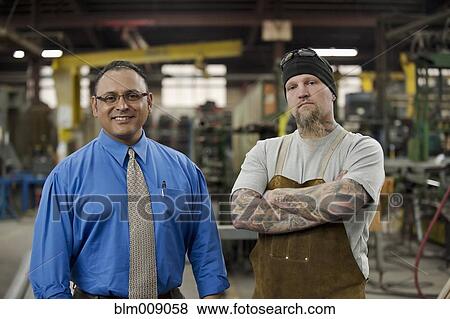 Manager and worker standing in factory View Large Photo Image Stock Photo - Manager and worker standing in factory. Fotosearch