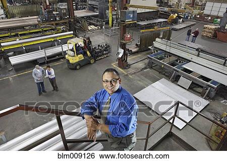Manager and workers standing in factory View Large Photo Image Stock Photograph - Manager and workers standing in factory. Fotosearch