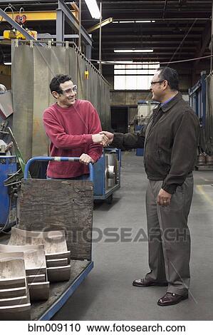 Manager shaking worker's hand in factory View Large Photo Image Stock Image - Manager shaking worker's hand in factory. Fotosearch