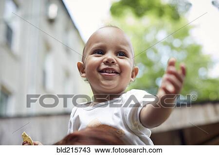 Stock Image - Mixed race baby boy smiling outdoors. Fotosearch